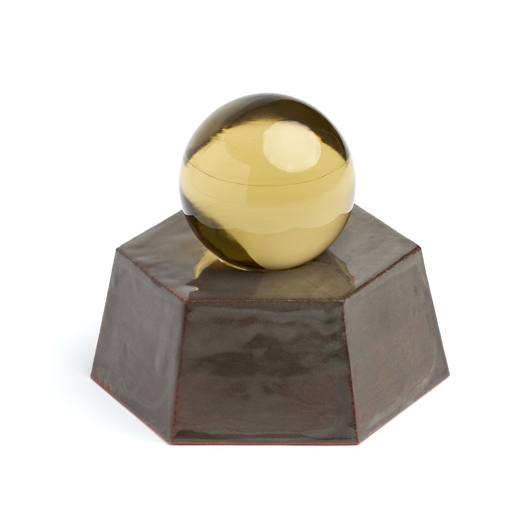 Eight Willow ceramic vessel seen from above, the amber orb catching the light on the glazed hexagon.
