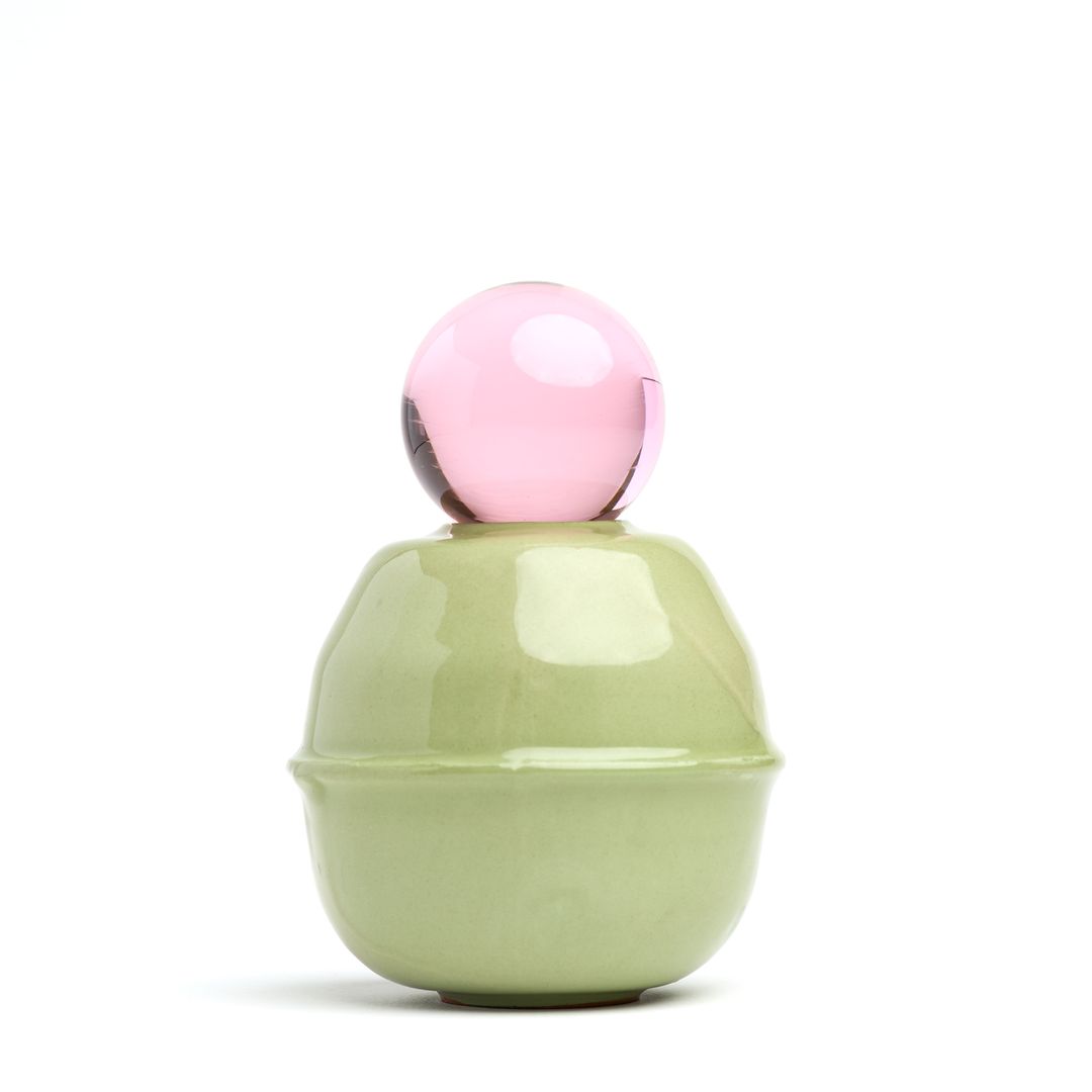 Rose Interval ceramic vessel on white, a pale green glazed form holding a glass orb.